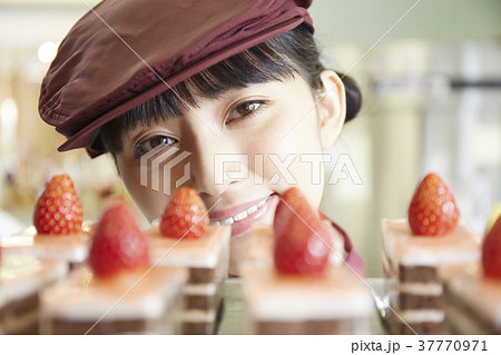 ケーキ屋でアルバイトをする女性の写真素材