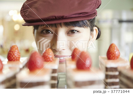 ケーキ屋でアルバイトをする女性 37771044