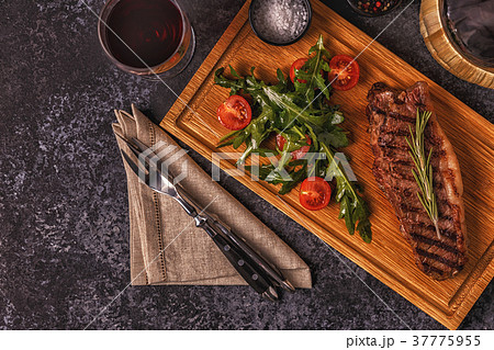 Beef steak on a dark background. 37775955