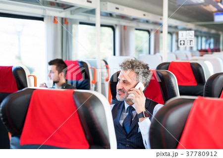 Mature businessman with smartphone travelling by 37780912