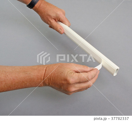 Handyman removing protection from adhesive layer Handyman removing protection from adhesive layer 37782337