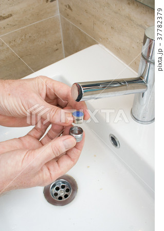 Plumber repairing a faucet filter in a bathroom 37782379