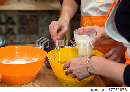 Female hands mix ingredients for dough Female hands mix ingredients for dough 37782878