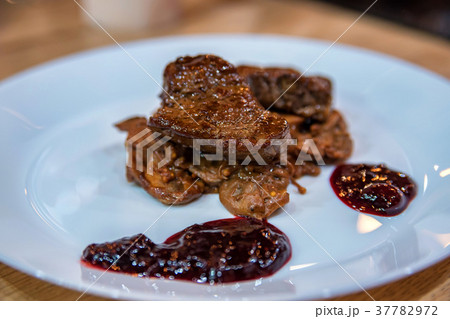 Close up pieces of roasted beef with jam on plate Close up pieces of roasted beef with jam on plate 37782972