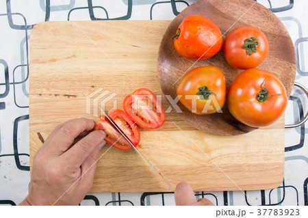 Chef cutting tomato before cooking with knife Chef cutting tomato before cooking with knife 37783923