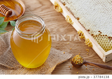 Honey jar, bee pollen and honeycombs on wooden table Honey jar, bee pollen and honeycombs on wooden table 37784138