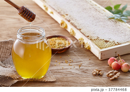 Honey jar, bee pollen and honeycombs on wooden table Honey jar, bee pollen and honeycombs on wooden table 37784468