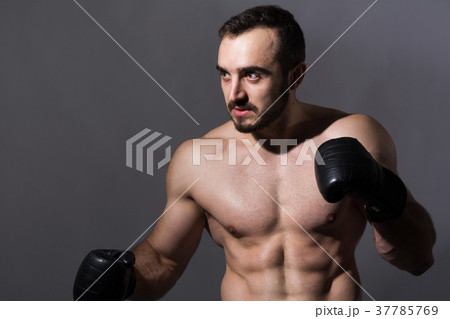 Portrait of a young muscular man in boxing gloves 37785769