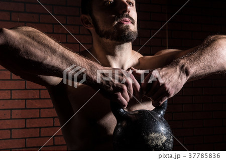 Close-up of a muscular man lifts kettlebell 37785836