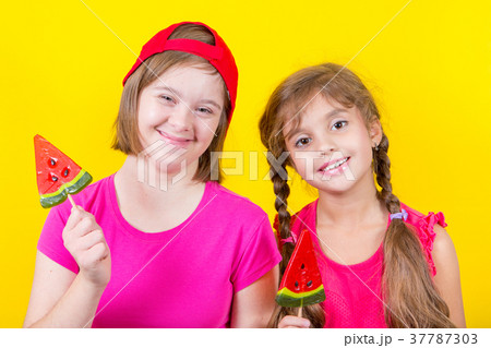 Girl Down syndrome and little girl with large Lollipop 37787303