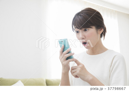 リビングでスマホを見る女性 リビングでスマホを見る女性 37798667