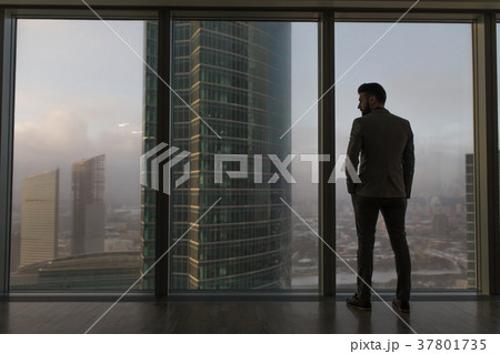 Rearview of a businessman looking out the window 37801735