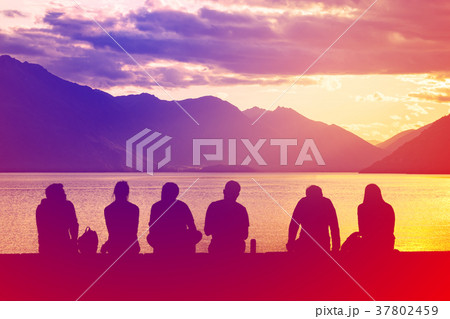 Silhouette Group of Young People Sitting on Beach Silhouette Group of Young People Sitting on Beach 37802459