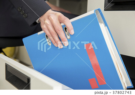 デスクの引出しから資料を取り出すビジネスマン手元 37802743