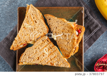 Peanut butter sandwiches with banana on dark plate 37803797