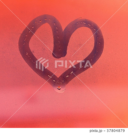 Heart painted with finger on foggy window 37804879