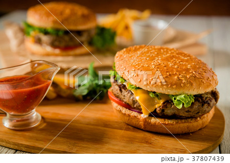 Burger with tasty beef, salad, sauce and tomato Burger with tasty beef, salad, sauce and tomato 37807439
