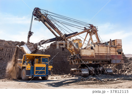 Excavator loading yellow dump truck 37812115