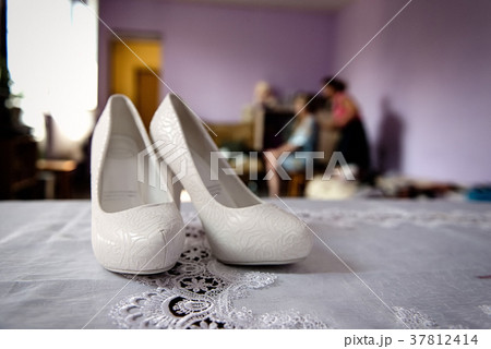 White wedding shoes in bride's room close 37812414