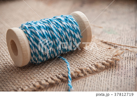 blue sewing thread spool bobbin on wooden table blue sewing thread spool bobbin on wooden table 37812719