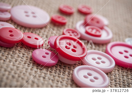 pink sewing buttons on hessian texture background pink sewing buttons on hessian texture background 37812726