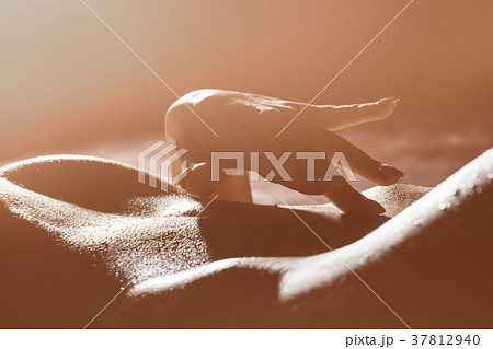 Close-up view of woman's hand touching her belly. 37812940