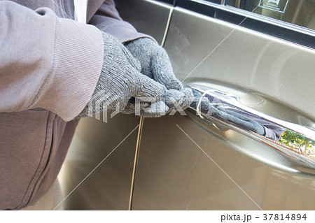 Thief trying to break into a car 37814894