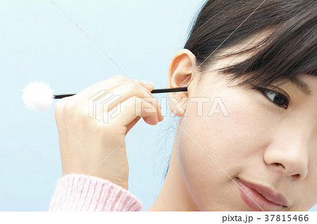 耳掃除をする若い女性の写真素材