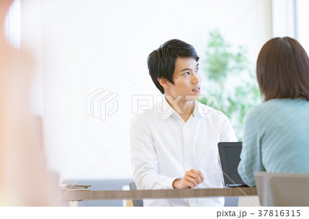 打ち合わせをする会社員　男性社員　女性社員　オフィスカジュアル　私服　中堅社員　ビジネスイメージ 37816315