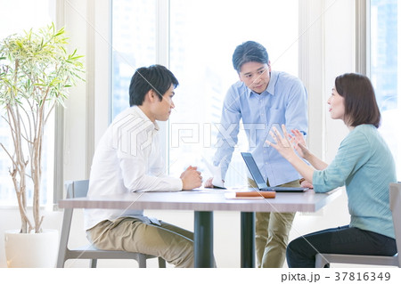 打ち合わせをする会社員 男性社員 女性社員 オフィスカジュアル 私服 中堅社員 ビジネスイメージの写真素材