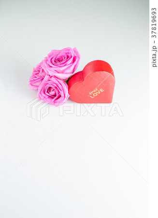 Red heart-shaped box and rose flowers . 37819693