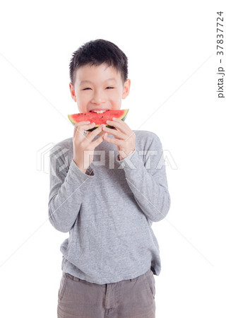 Young boy eating a slice of watermelon over white  37837724