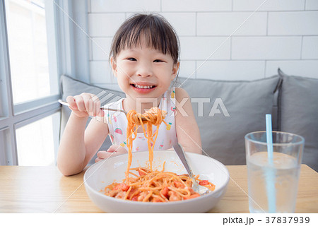 Little girl using fork eating spaghetti by herself Little girl using fork eating spaghetti by herself 37837939