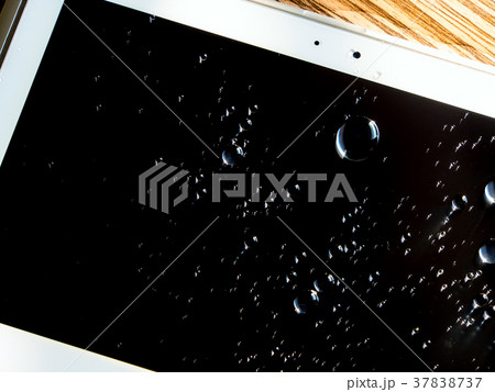 Drops of water spilled onto the tablet screen Drops of water spilled onto the tablet screen 37838737