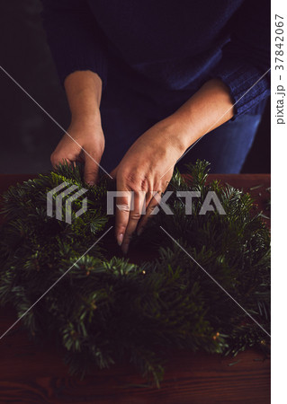 Woman makes a traditional Christmas wreath Woman makes a traditional Christmas wreath 37842067