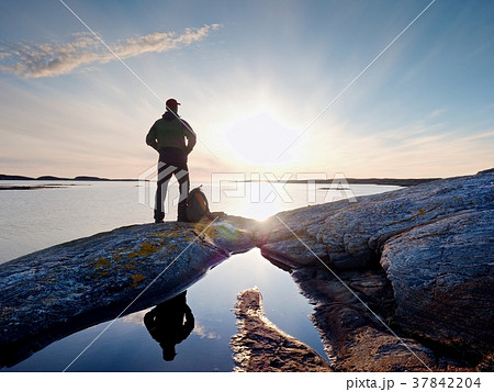 Young standing man with backpack. Hiker on stone Young standing man with backpack. Hiker on stone 37842204