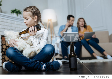 Little girl giving beer to her teddy bear Little girl giving beer to her teddy bear 37844535