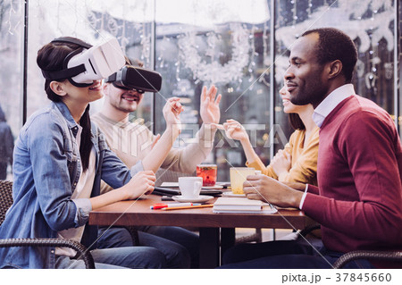 Charming two friends wearing VR headset Charming two friends wearing VR headset 37845660