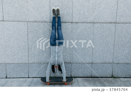 skateboarder doing a handstand on skateboard  37845704