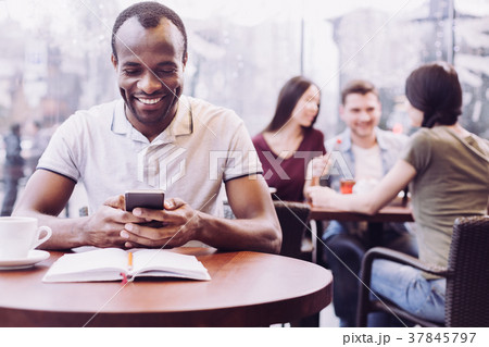 Adorable male student typing while cramming Adorable male student typing while cramming 37845797