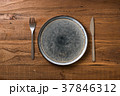 Plate on brown wooden background with utensils 37846312