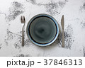 Plate on white wooden background with utensils 37846313
