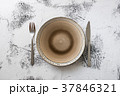 Plate on white wooden background with utensils 37846321
