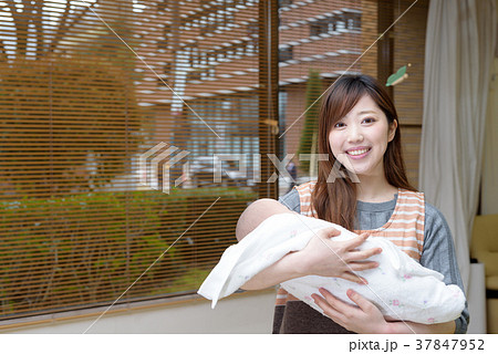 赤ちゃんの人形で練習する女性保育士の写真素材