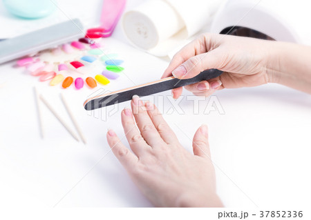 Woman doing manicure with black file Woman doing manicure with black file 37852336