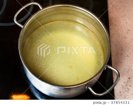 clear fat beef bouillon in steel stockpot 37854331