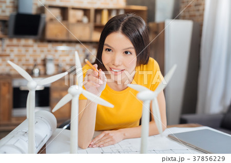 Smiling engineer pointing to the turbines while 37856229