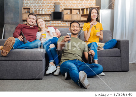 Young smiling people sitting together and watching 37856340