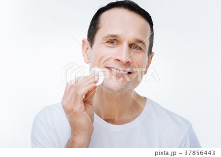 Pleasant nice man holding a cotton pad Pleasant nice man holding a cotton pad 37856443