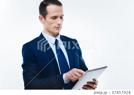 Serious nice businessman using a tablet 37857028